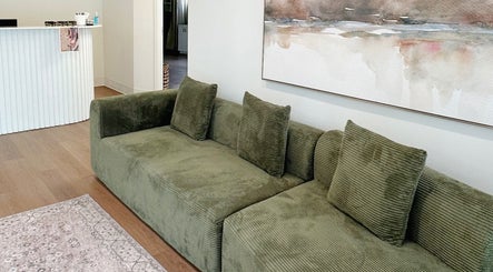 Cozy seating at A.B. SKINCARE STUDIO, Winnipeg, Manitoba, CA, featuring olive green sofa and modern decor.