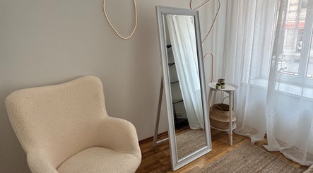 Elegant beauty corner at Madara Z Beauty, Rīga, LV, with a comfy chair and mirror.