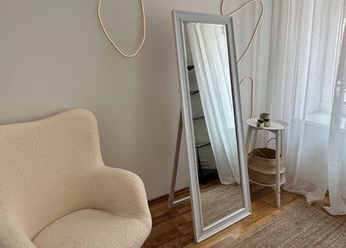 Elegant room with a mirror, chair, and decor at Madara Z Beauty in Rīga, LV.