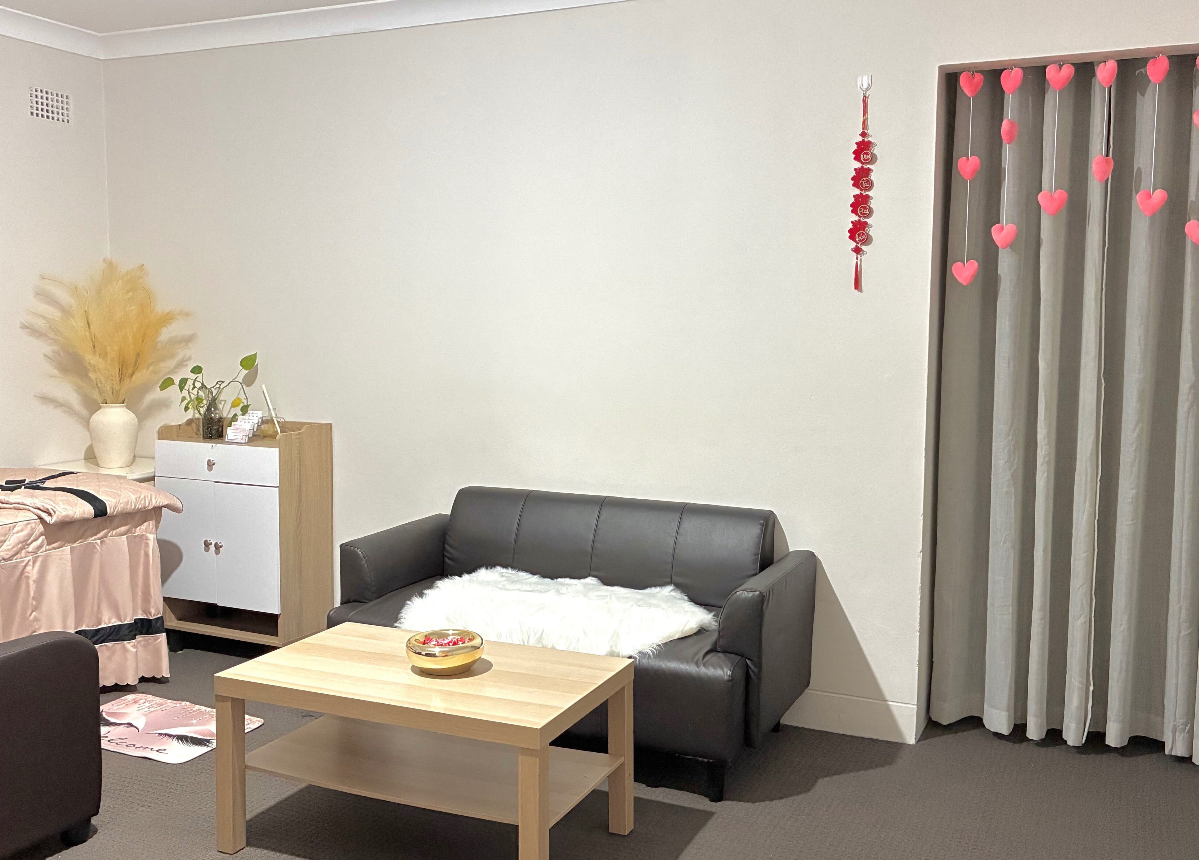 Inviting cozy lounge at Sweety Lashes salon, Campsie, New South Wales, AU. Modern decor with pink accents.