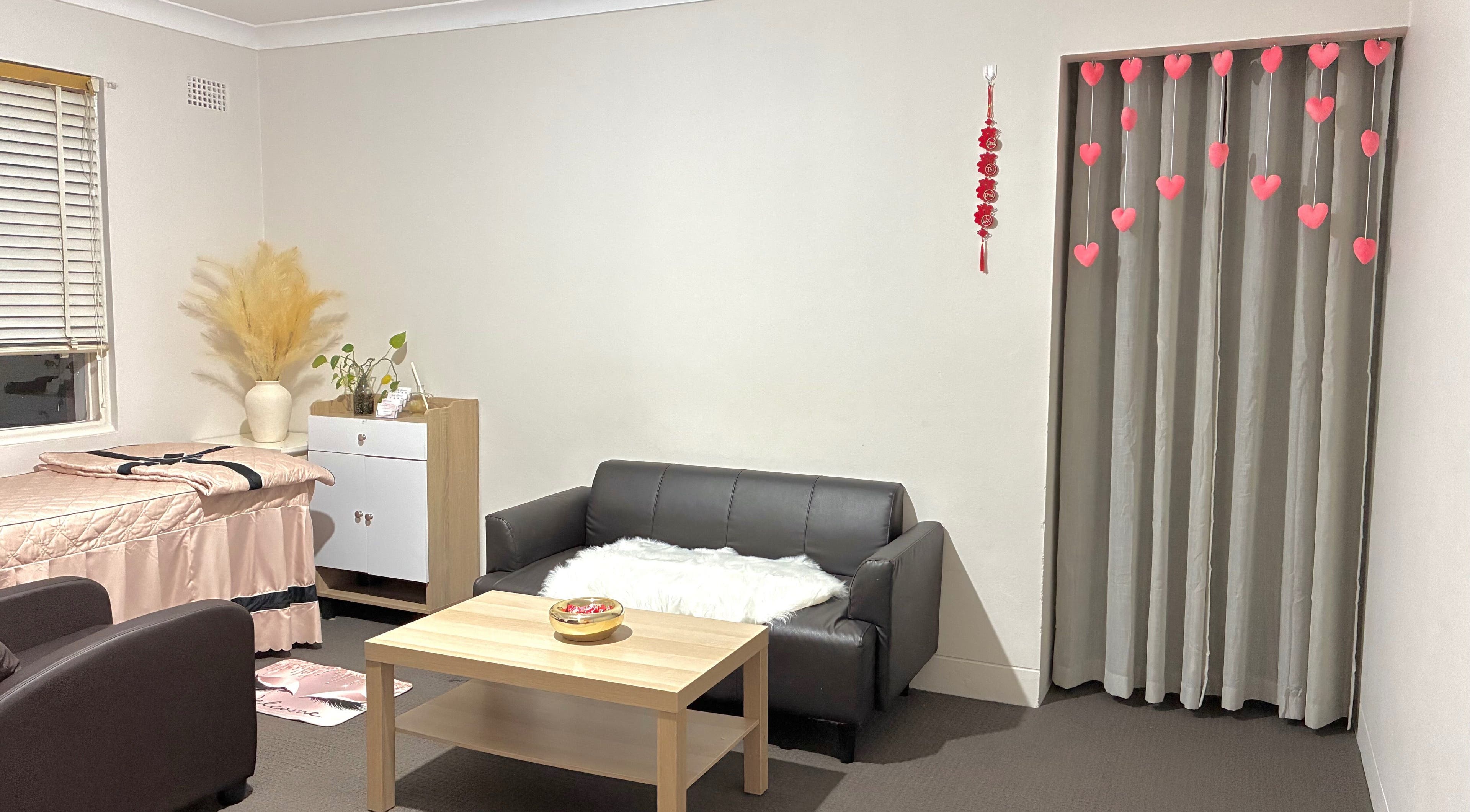 Inviting cozy lounge at Sweety Lashes salon, Campsie, New South Wales, AU. Modern decor with pink accents.