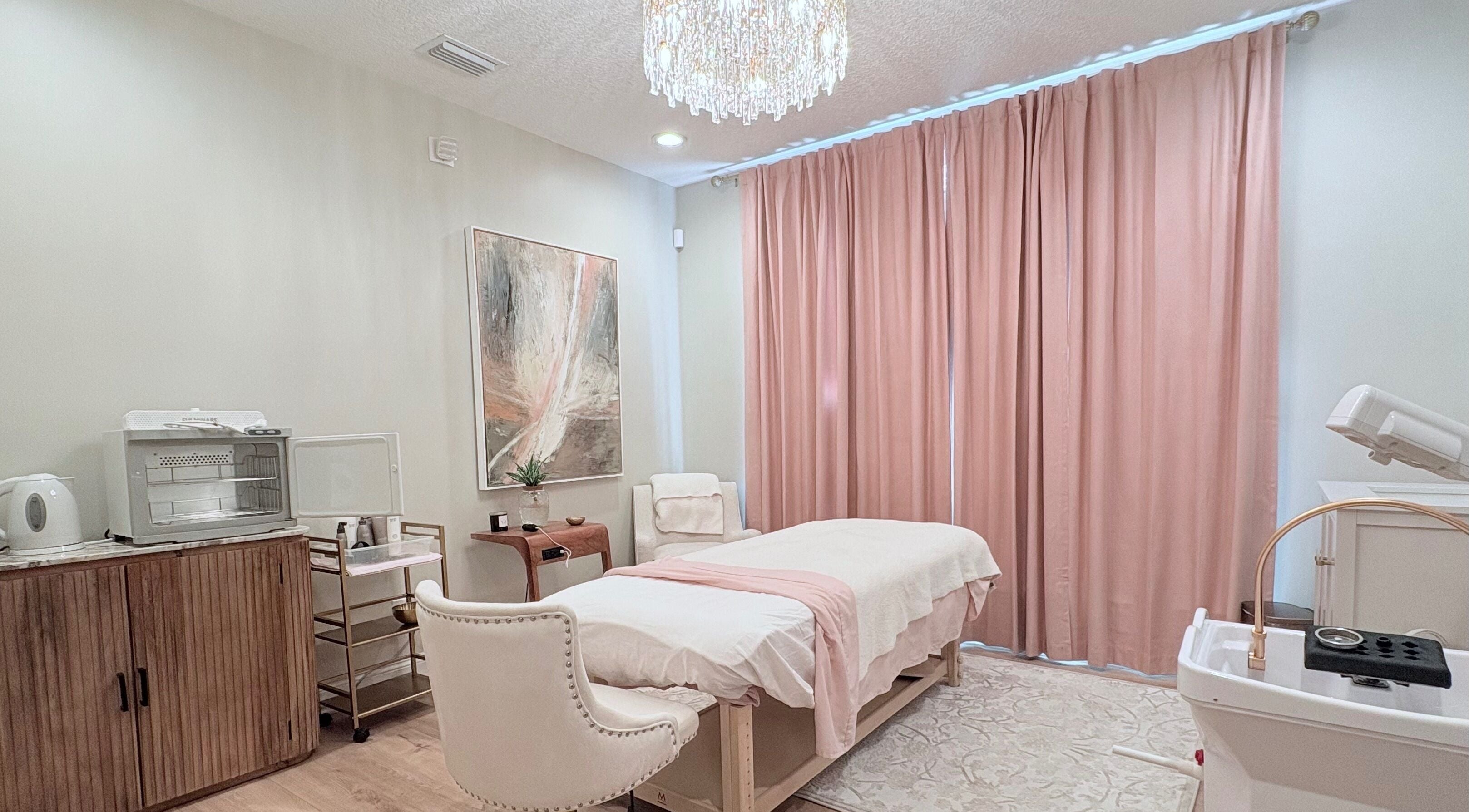Relaxing spa room at Stylist Memee in Jacksonville, Florida, US with massage table and soft pink curtains.