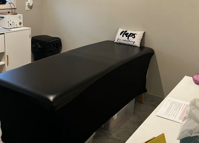 A tranquil waxing treatment room at Waxed by Ky in Fort Myers, Florida, US, with a sleek black treatment bed.