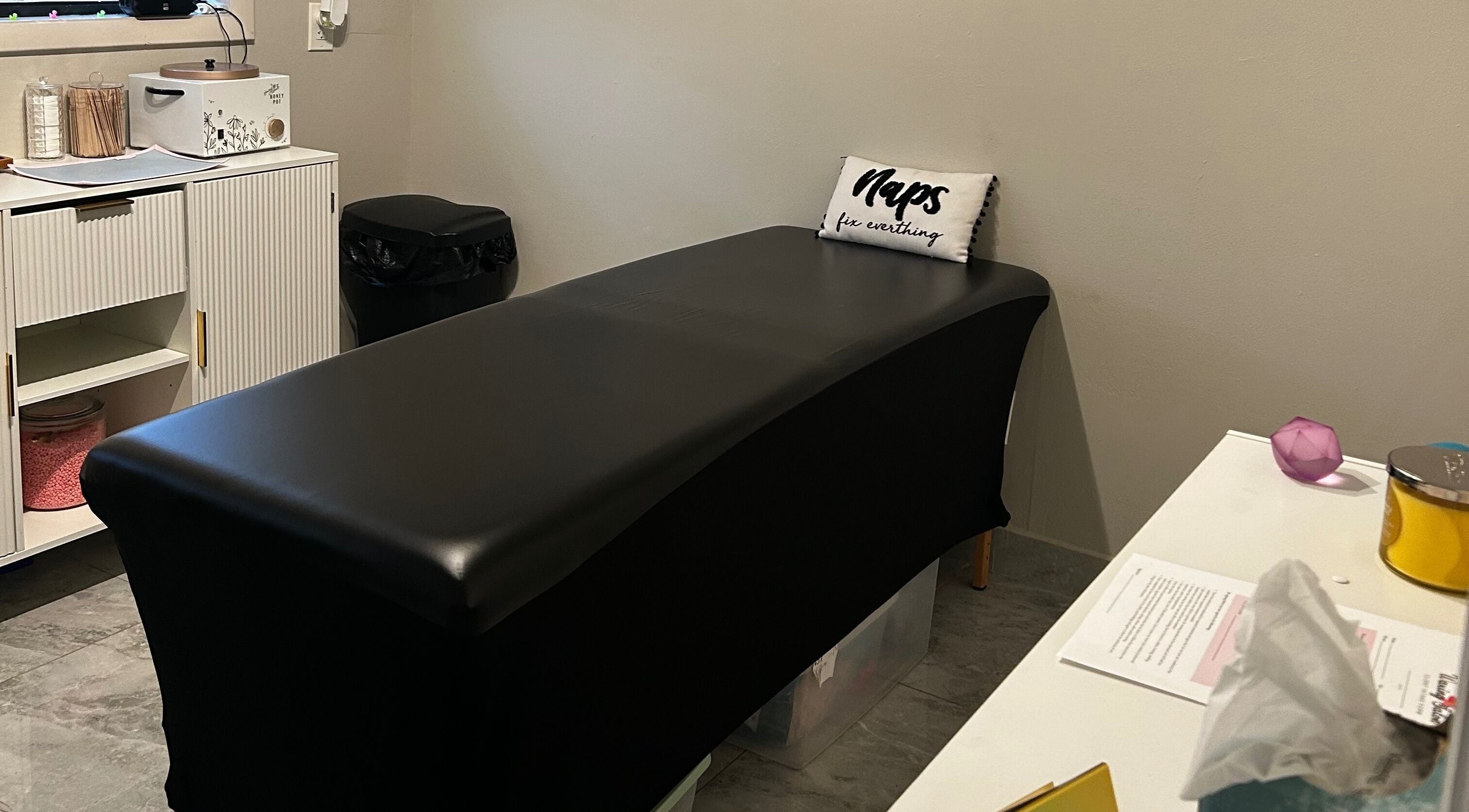 Comfortable waxing station at Waxed by Ky, Fort Myers, Florida, US featuring a sleek black table.