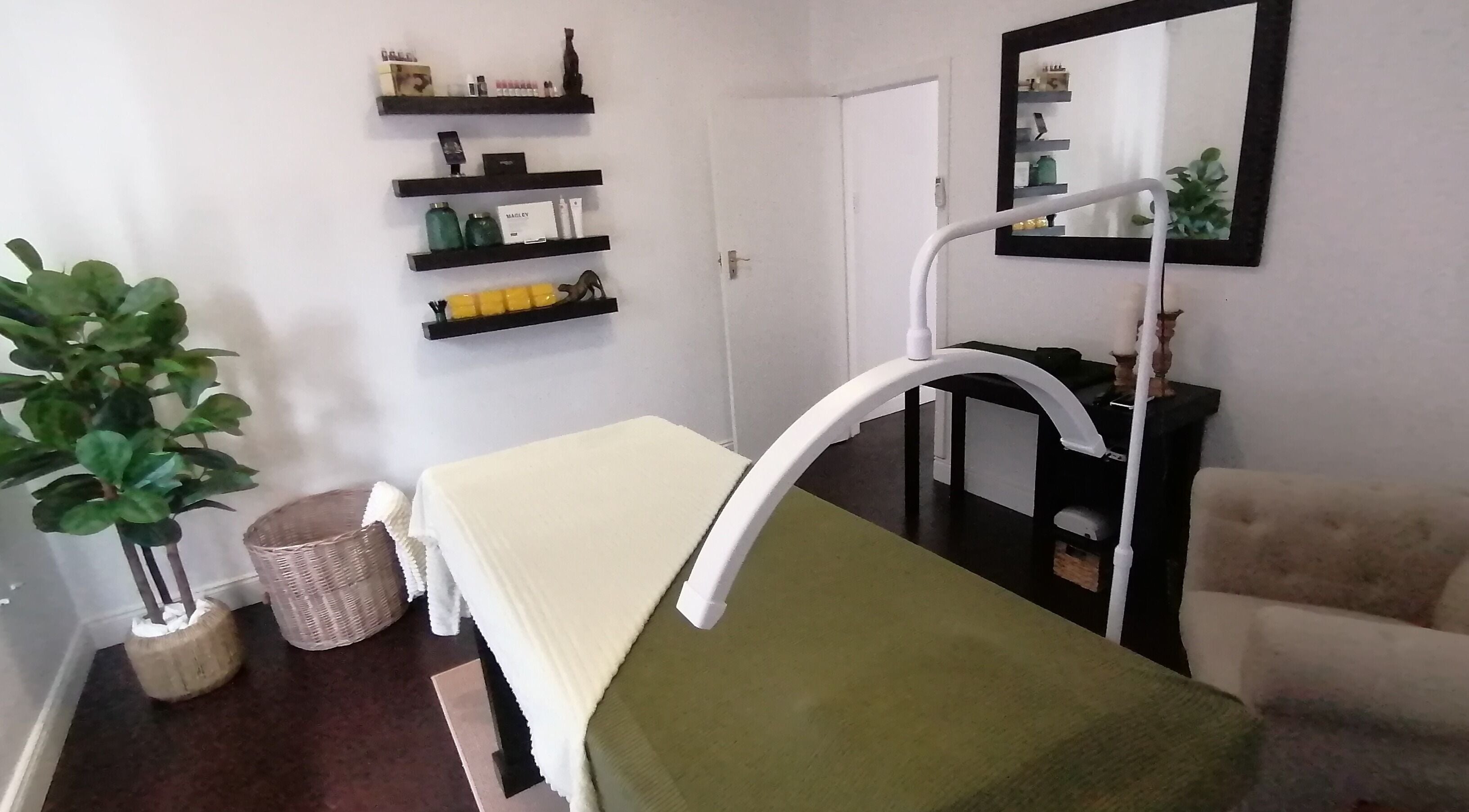 Charlize Smit Aesthetics in Pretoria, Gauteng, ZA. Cozy spa room with treatment bed and greenery.