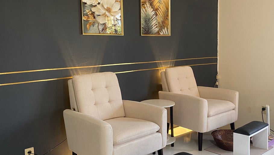 Chic seating area at Ana’s Nails Studio, Paramaribo, Paramaribo, SR, featuring plush beige chairs and gold accents.