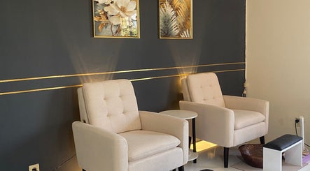 Chic seating area at Ana’s Nails Studio, Paramaribo, Paramaribo, SR, featuring plush beige chairs and gold accents.