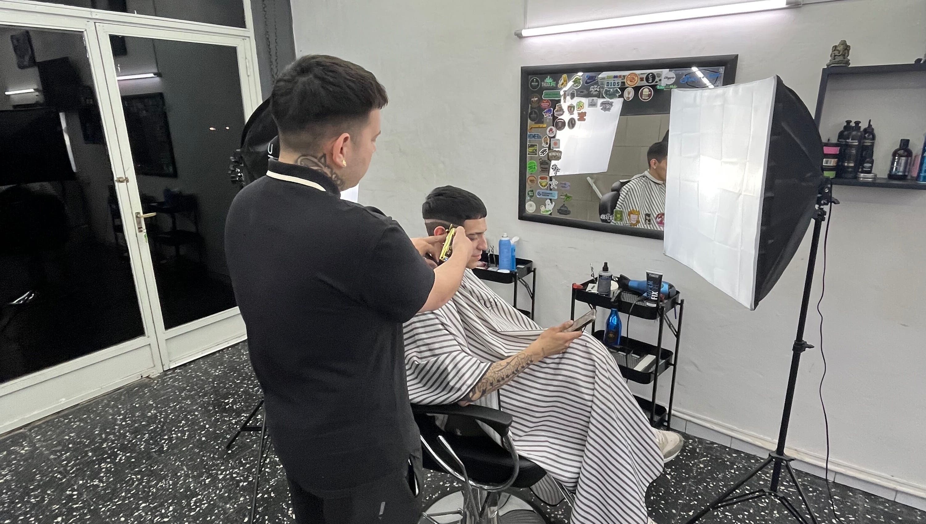 Barbero trabajando en Sicilia barbería, Rosario, Santa Fe, AR. Cliente relajado durante el corte de cabello.