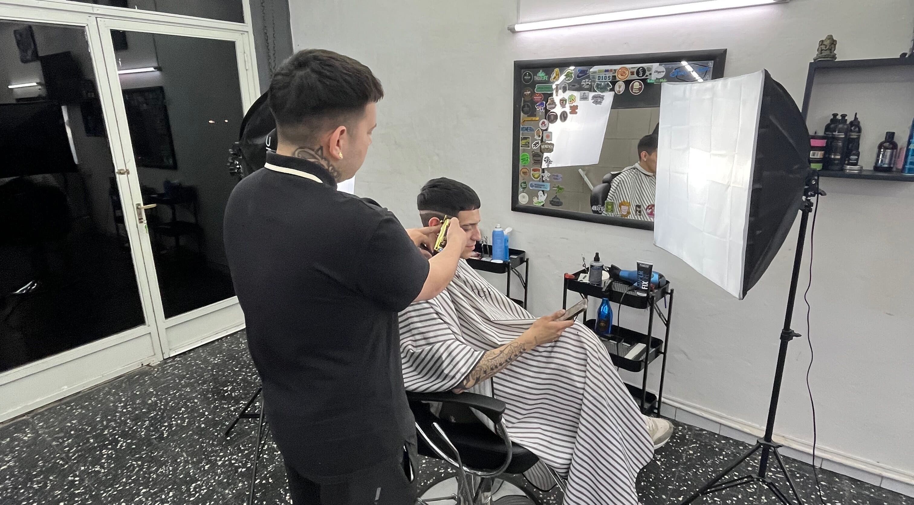 Barbero trabajando en Sicilia barbería, Rosario, Santa Fe, AR. Cliente relajado durante el corte de cabello.