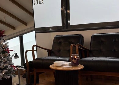Elegant seating area at Luxe Lash by DK, Newcastle upon Tyne; leather chairs and Christmas decor create a warm ambiance.