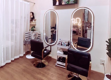 Chic salon setup at Bangkok Beauty Studio, Krung Thep Maha Nakhon, TH with mirrors and stylish chairs.
