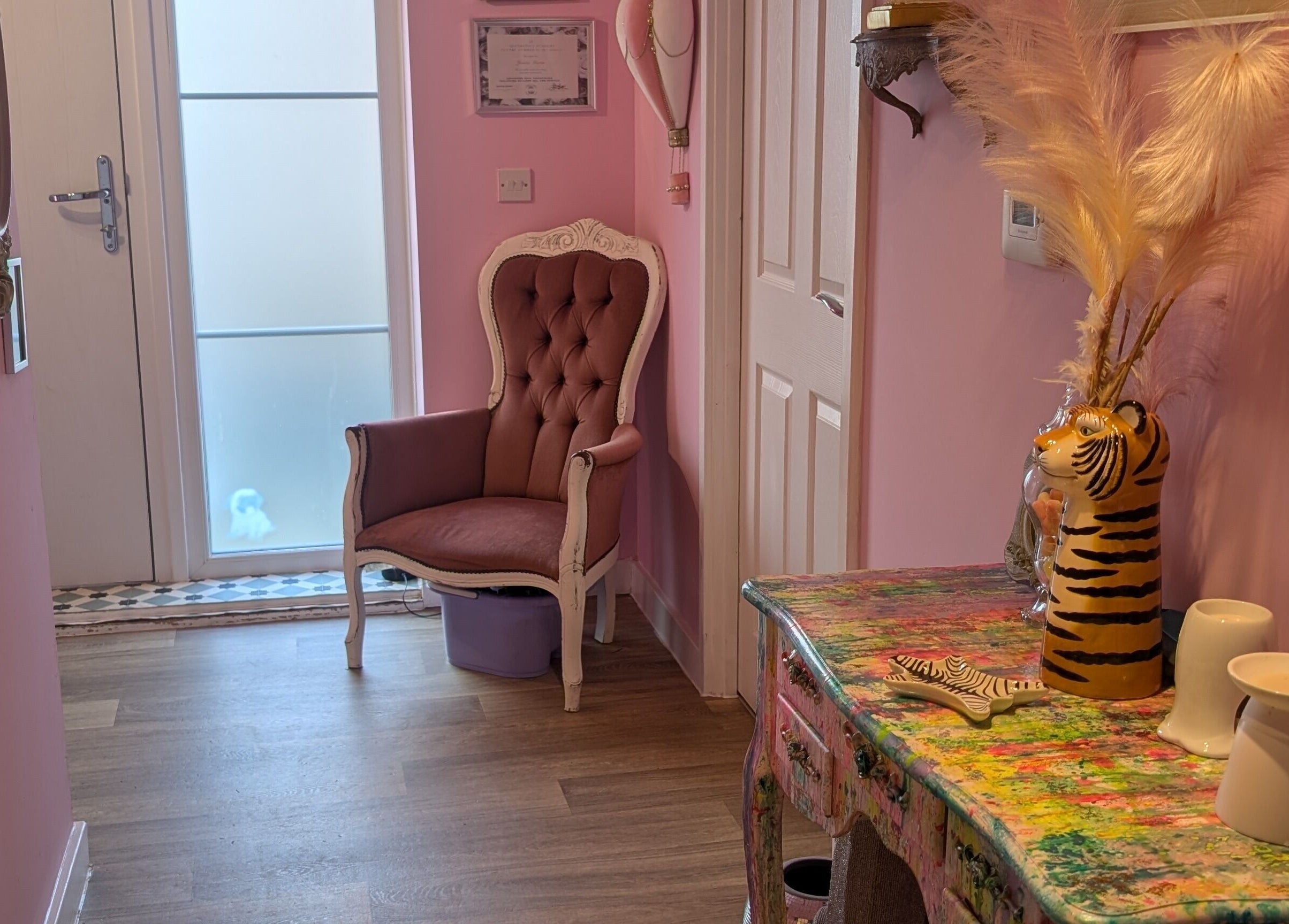 Elegant entryway at J.m.nails, Fair Oak, England, showcasing a plush chair and colorful decor.