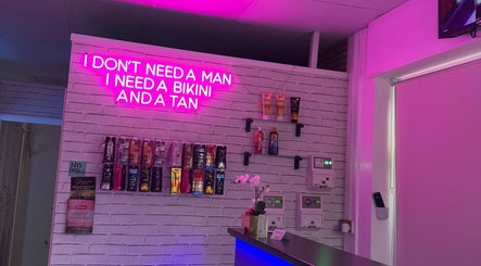 Chic interior of Only Tans in Wickford, England, GB, featuring pink neon lights and tanning products displayed.
