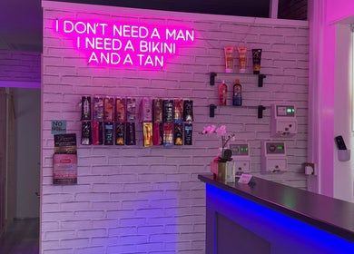 Bright neon sign with tan products at Only Tans, Wickford, England, GB enhancing vibrant ambiance.