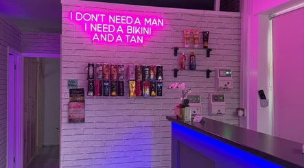 Bright neon sign with tan products at Only Tans, Wickford, England, GB enhancing vibrant ambiance.