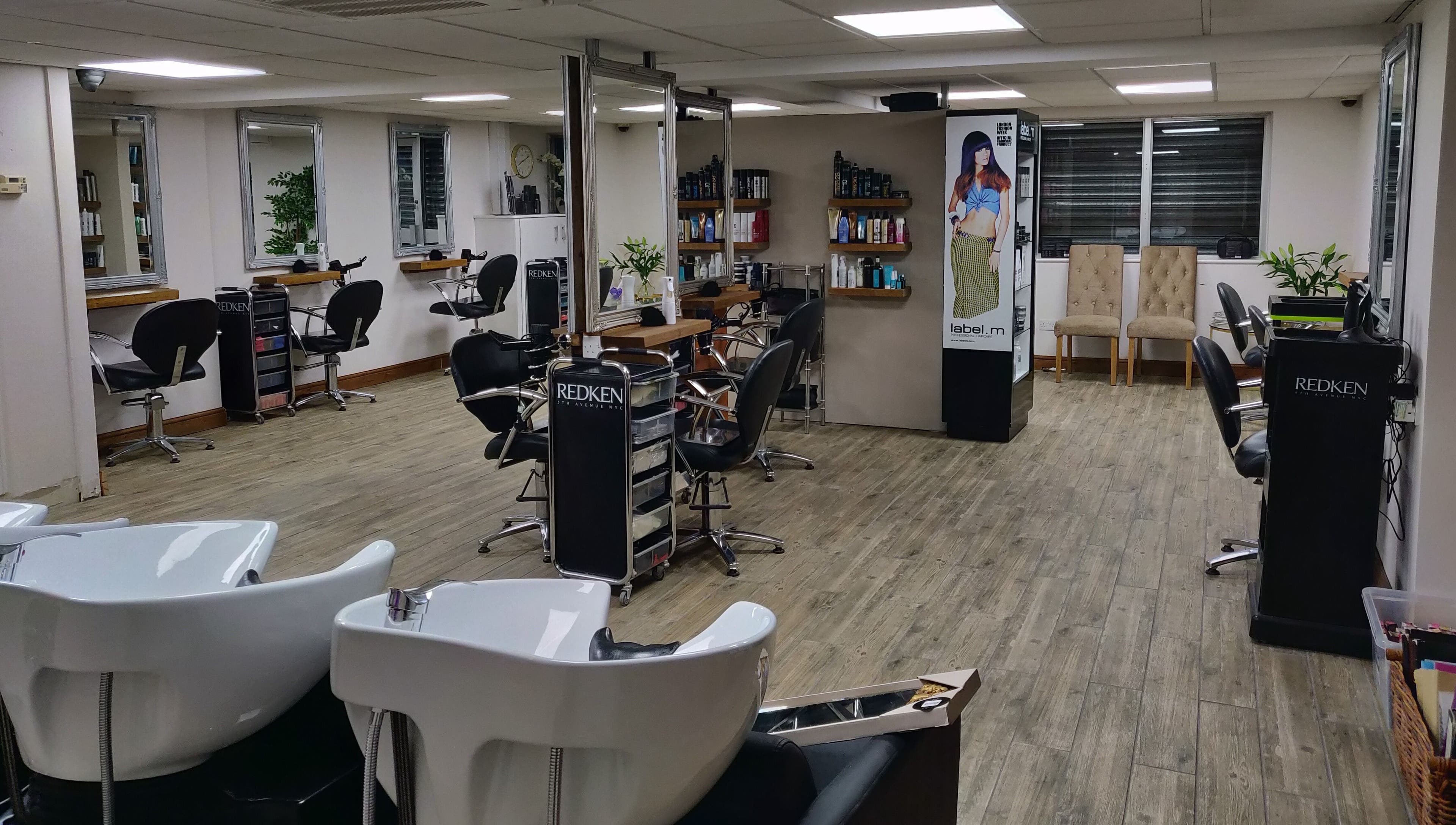Chic interior of Mane Creations salon in Colchester, England, GB featuring workstations and vibrant decor.