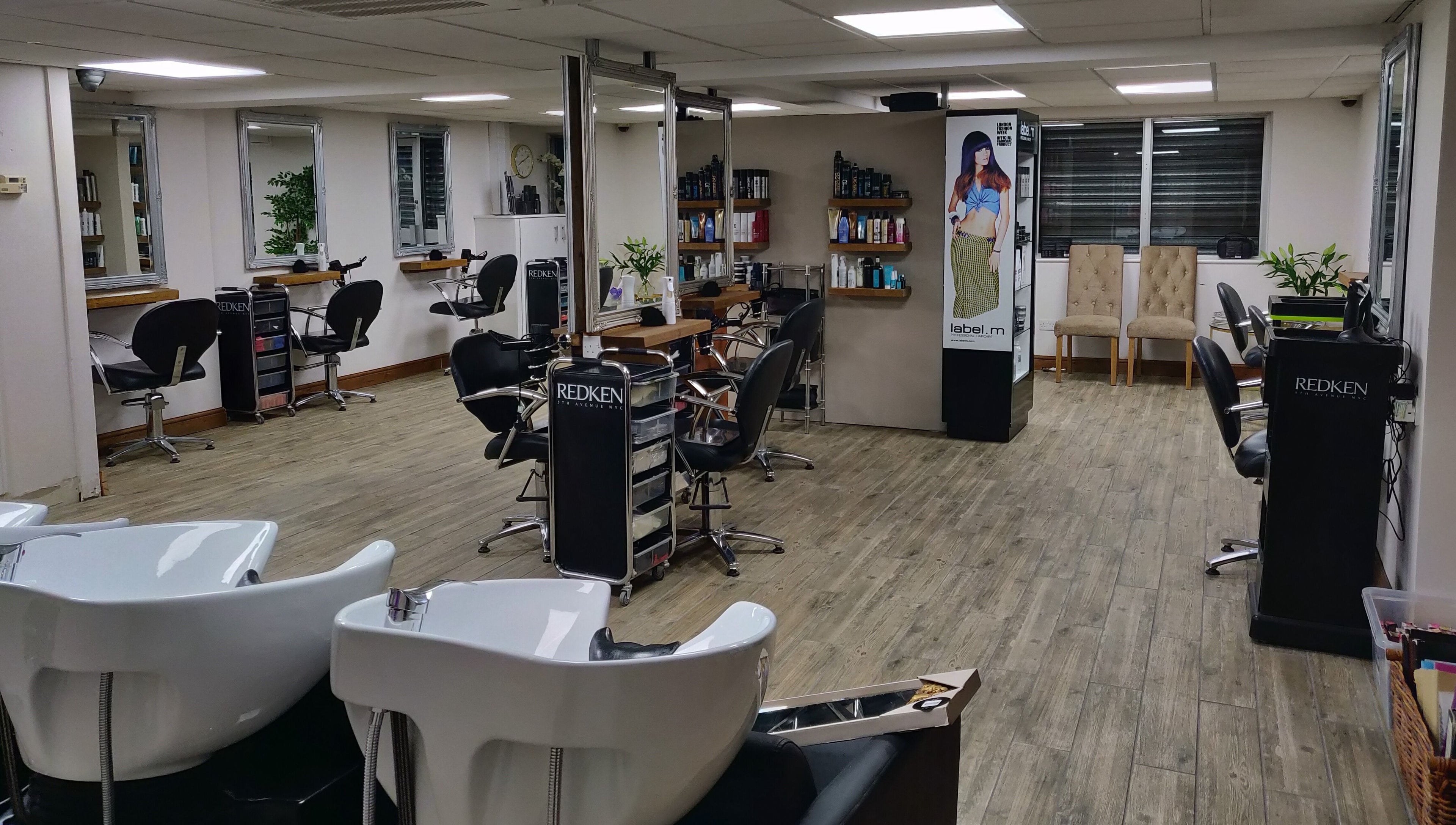 Chic interior of Mane Creations salon in Colchester, England, GB featuring workstations and vibrant decor.