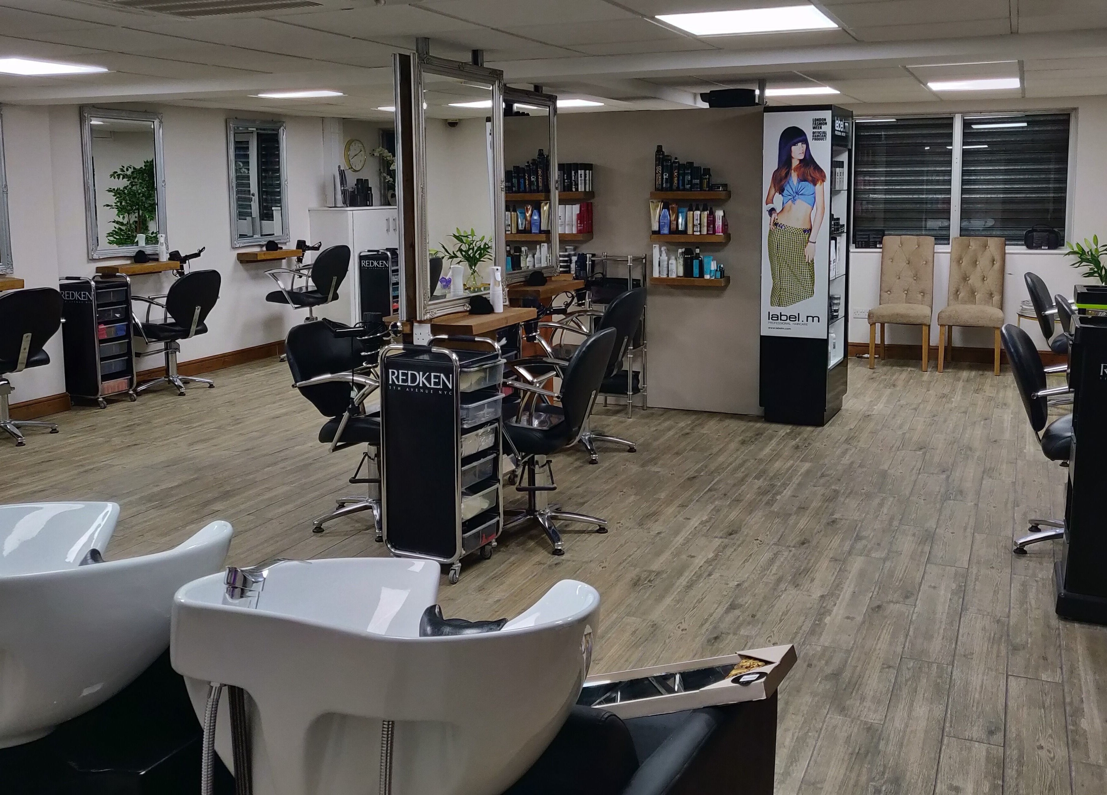 Chic interior of Mane Creations salon in Colchester, England, GB featuring workstations and vibrant decor.