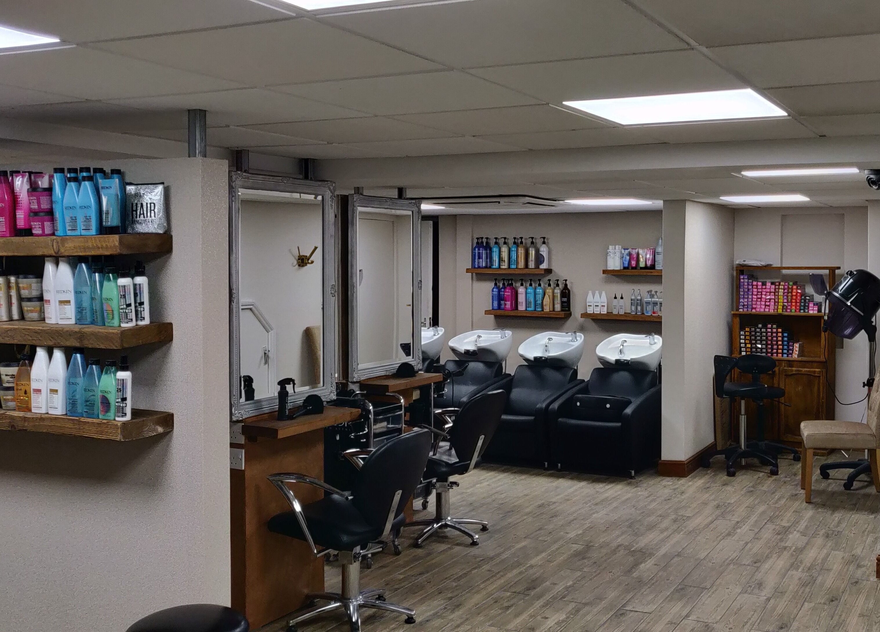 Elegant salon interior of Mane Creations, Colchester, England, GB, featuring stylish chairs and product shelves.