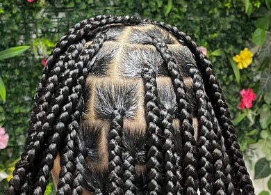 Complexe vlechten bij Midonahair, Utrecht, Utrecht, NL, met kleurrijke bloemen op de achtergrond.