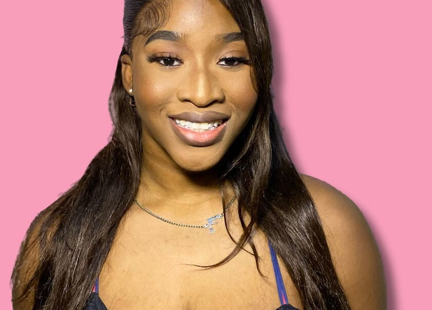 Happy woman at Dime Divine Looks, Kingston, St. Andrew Parish, JM, showcasing stunning makeup and hairstyle.