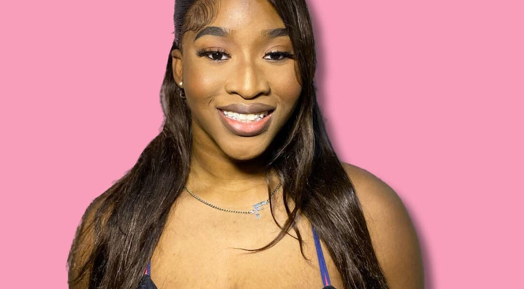 Happy woman at Dime Divine Looks, Kingston, St. Andrew Parish, JM, showcasing stunning makeup and hairstyle.