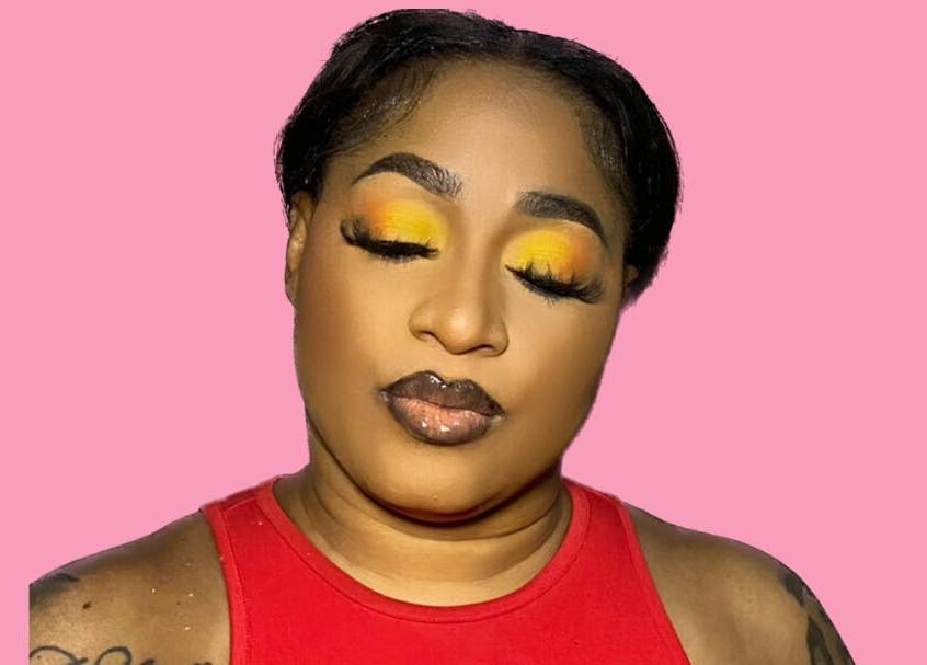 A woman with vibrant makeup poses at Dime Divine Looks, Kingston, St. Andrew Parish, JM.