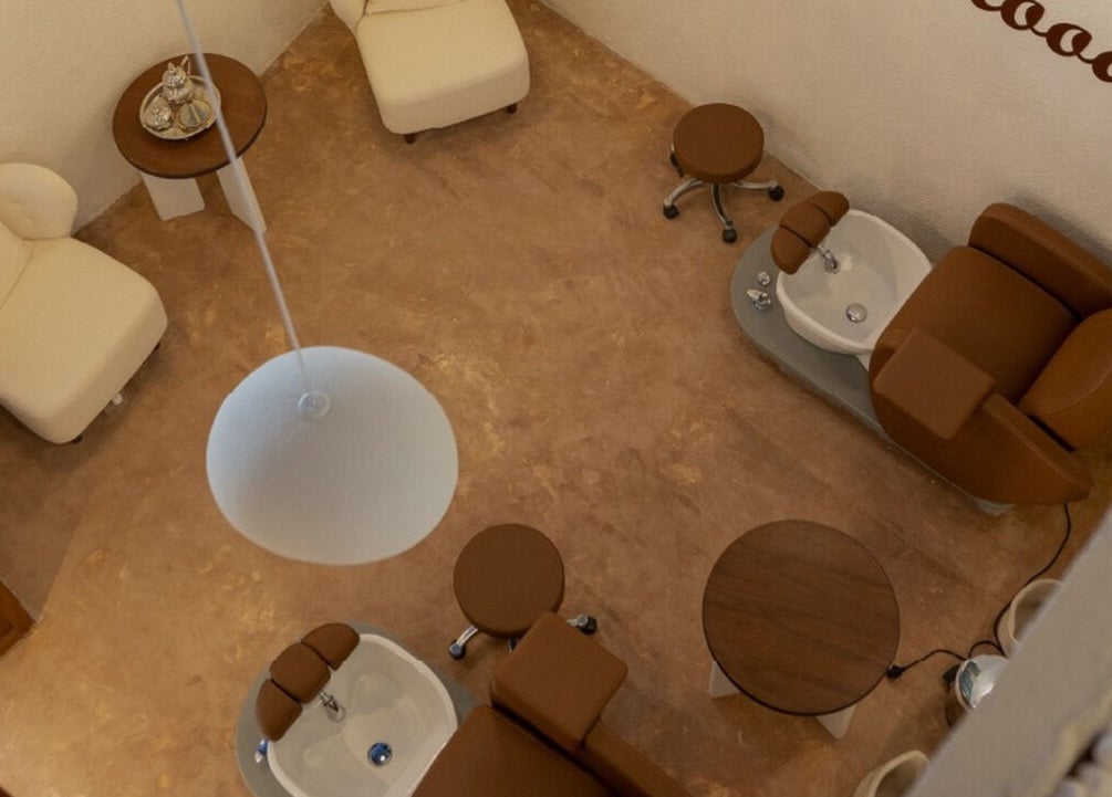 صورة لمنطقة استرخاء في سبا سان بالرياض، منطقة الرياض، السعودية بتصميم أنيق وكرسي بني.