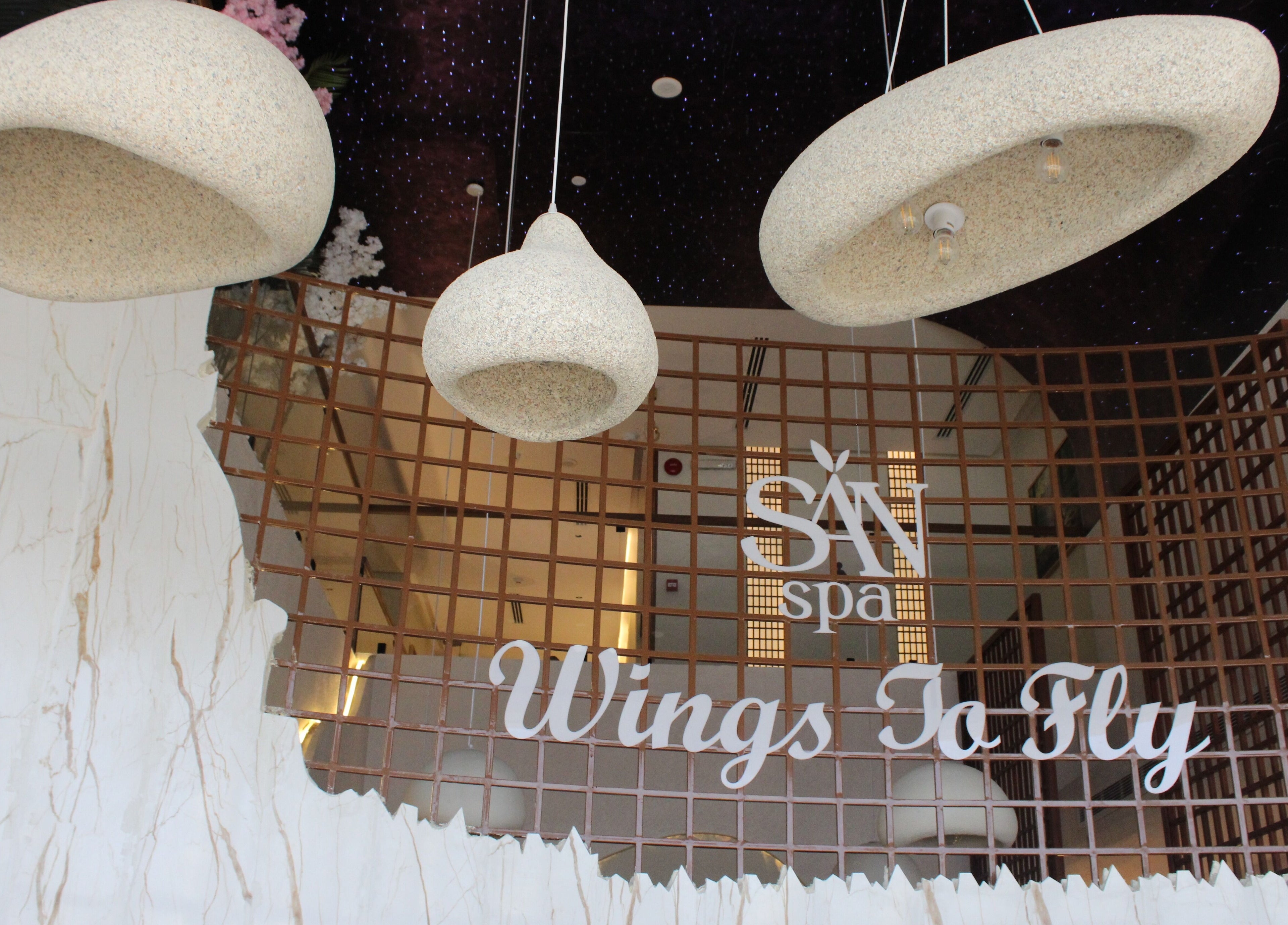 مدخل سان سبا في الرياض، الرياض، يتضمن لافتة ترحيبية تحت الأضواء المعلقة.