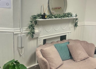 Isa’s Nail Boutique in Dublin, IE features a cozy couch with chic decor and plants, offering a serene atmosphere.