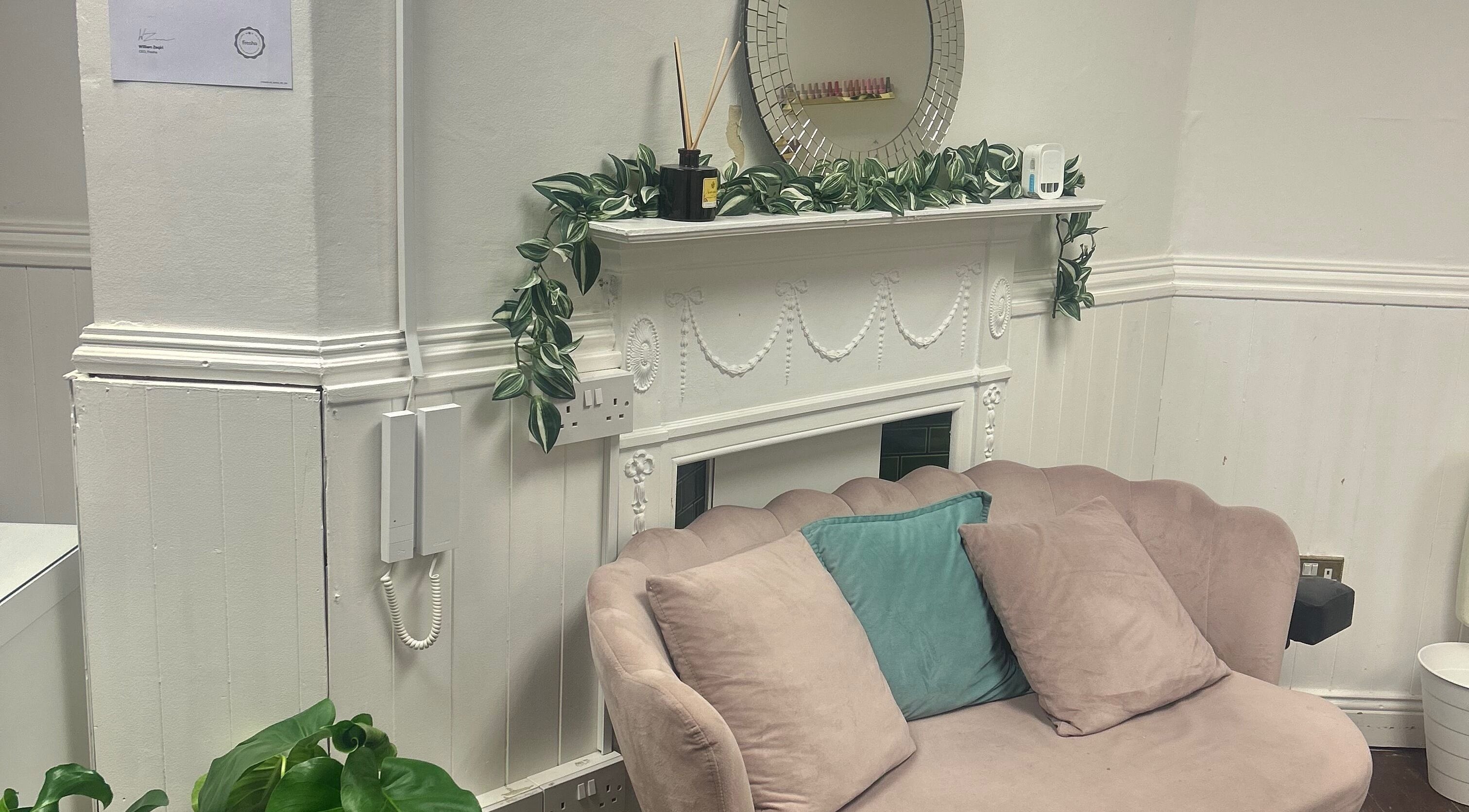 Elegant seating area with plush sofa and mirror at Isa’s Nail Boutique, Dublin, County Dublin, IE.