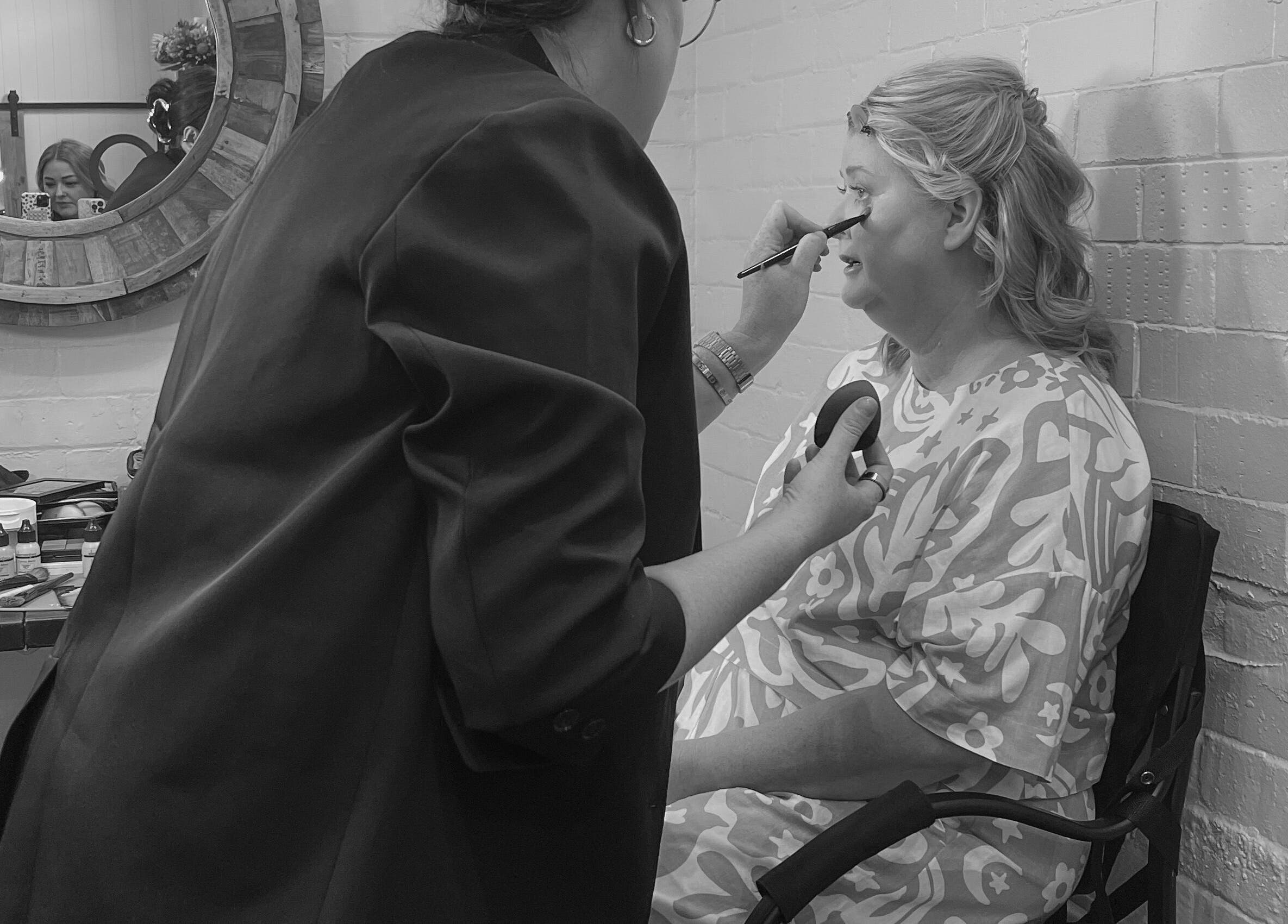 Makeup artist at Colestè Twilley Makeup, Toowoomba Region, applies eyeshadow to client.