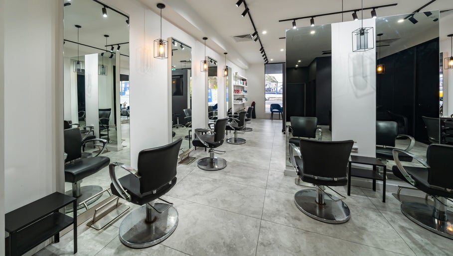 Modern salon interior at Envy Hair and Beauty, Five Dock, New South Wales, AU, featuring sleek black chairs.