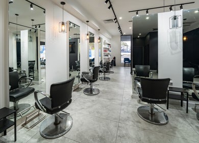 Modern salon interior at Envy Hair and Beauty, Five Dock, New South Wales, AU, featuring sleek black chairs.