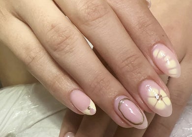 Manicura artística en Nails by Angie, Sardinal, CR. Diseño floral con esmalte rosa y detalles dorados.