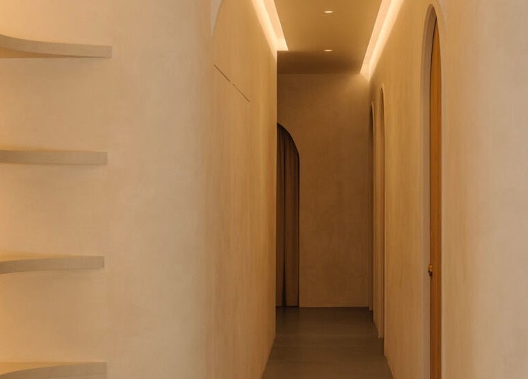Elegant hallway at NEAU, Singapore, Singapore, SG, featuring soft lighting and curved shelves.