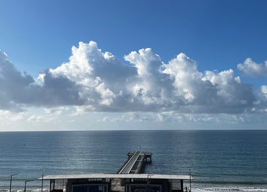 Scenic pier view near Selah Massage Therapy, Bournemouth, England, GB, against a vast blue sky and sea.