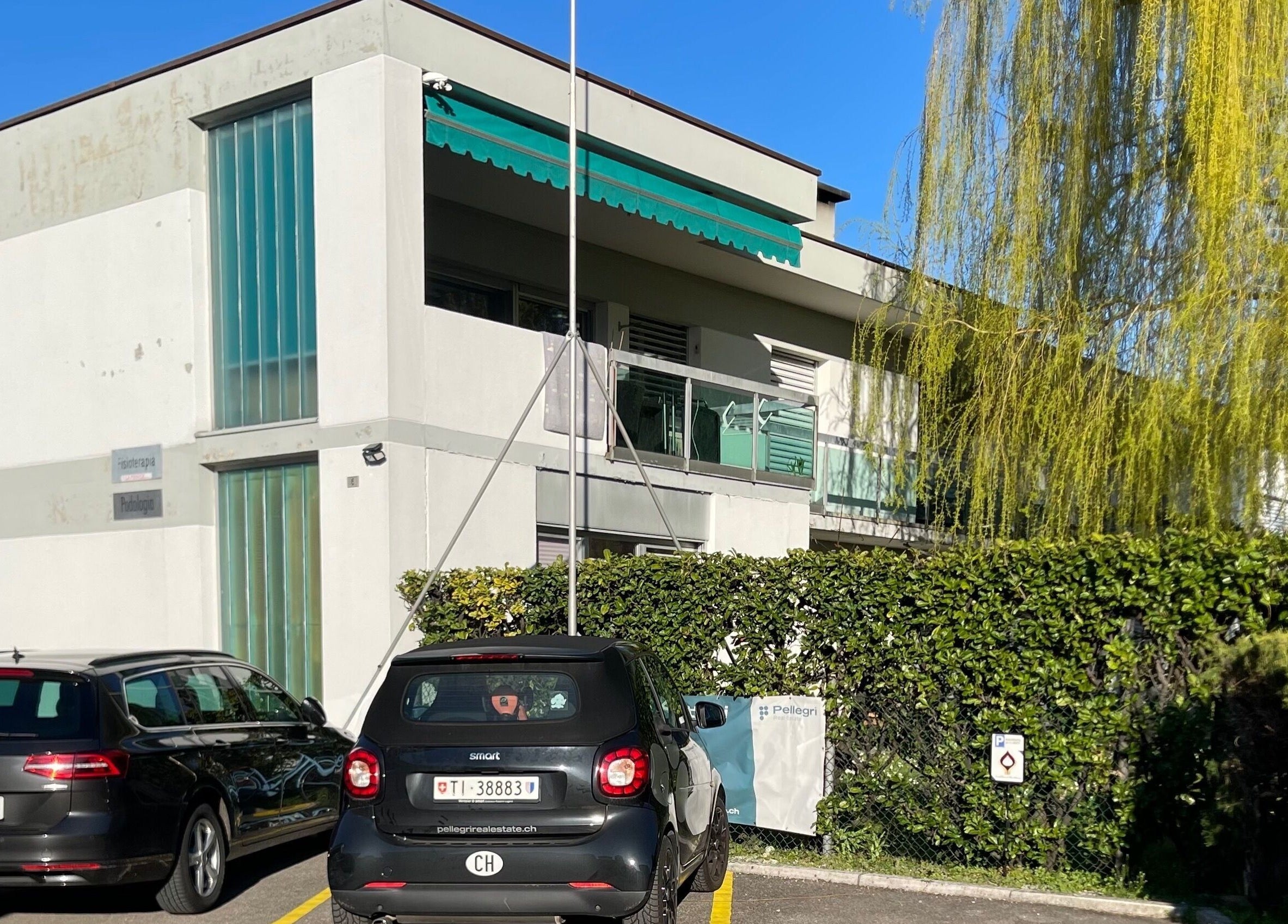 Exterior view of GrandRelax at ThaiMassage in Ascona, Ticino, CH with modern architecture and green surroundings.