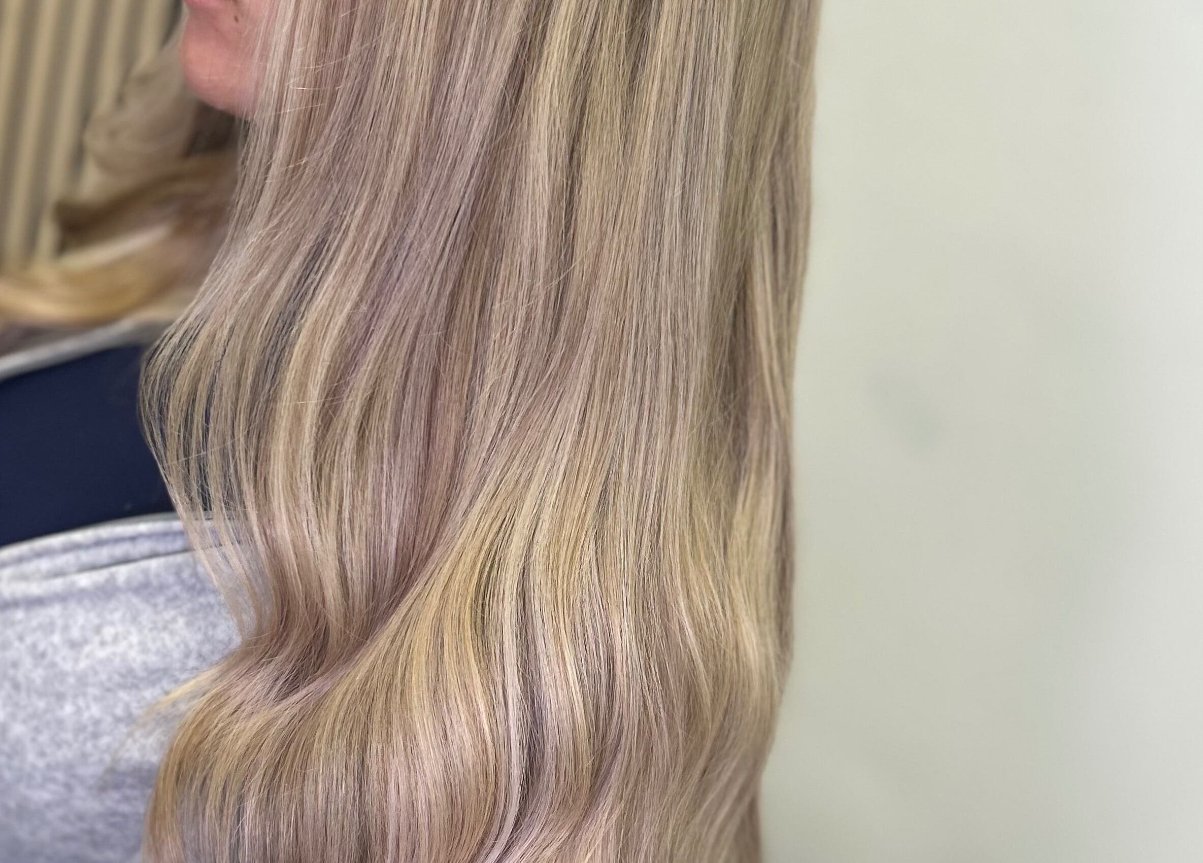 Long, silky blonde hair styled in soft waves at Olivia Tyman Hair Design, Elland, England, GB.