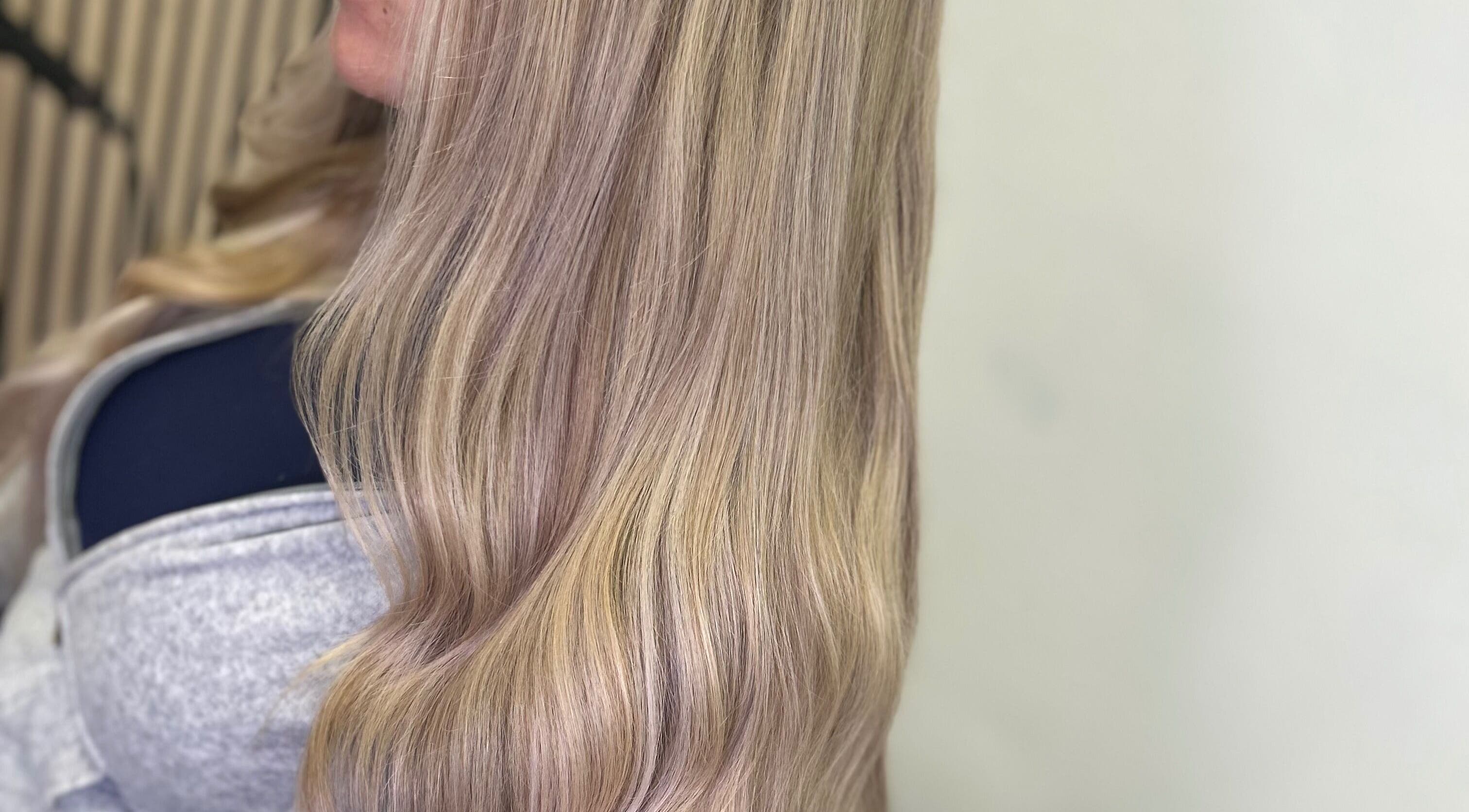 Long, silky blonde hair styled in soft waves at Olivia Tyman Hair Design, Elland, England, GB.