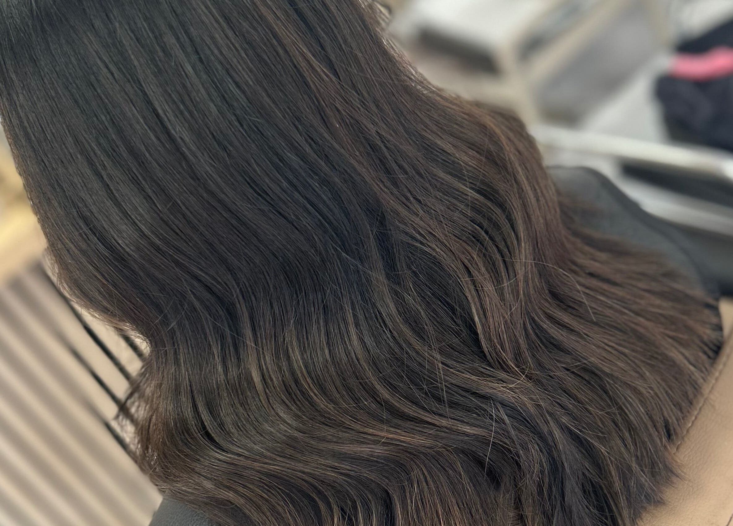 Elegant dark hair styled in soft waves at Olivia Tyman Hair Design, Elland, England, GB.