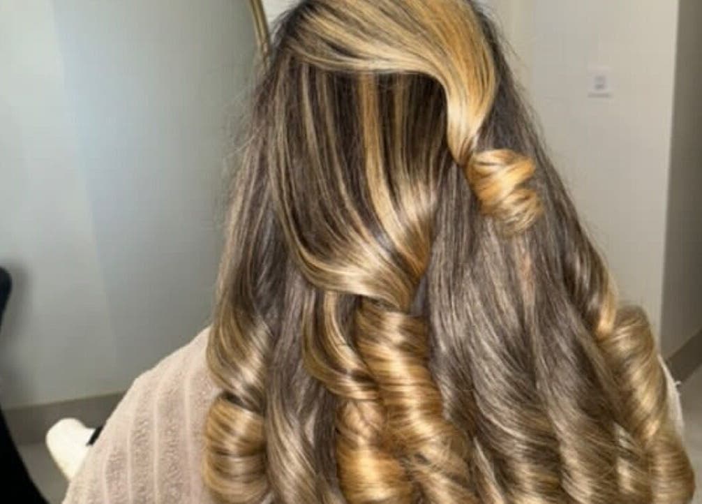 Elegant blonde curls styled at Olivia Tyman Hair Design in Elland, England, GB. Perfect for a glamorous look.