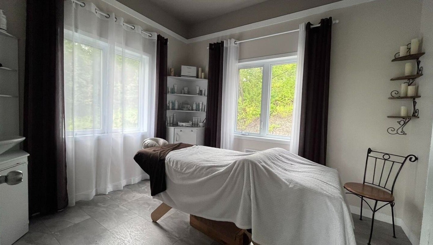 Salle de massage paisible à Spa Le Sensoriel, Sherbrooke, Québec, CA avec table de soin et décor apaisant.