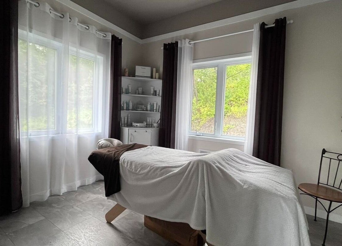 Salle de massage paisible à Spa Le Sensoriel, Sherbrooke, Québec, CA avec table de soin et décor apaisant.