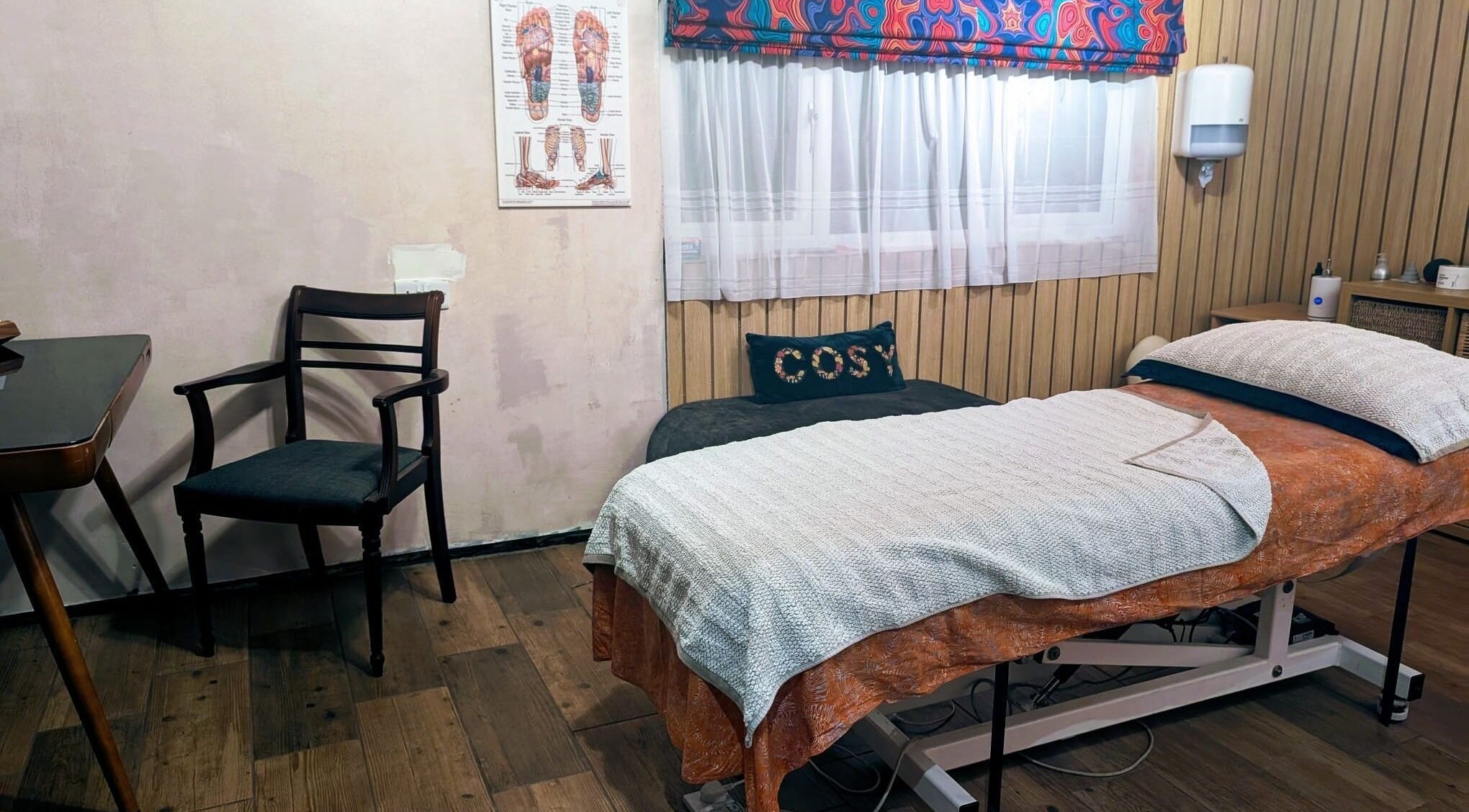 Cozy massage room at AG Sports Massage Therapy, Fareham, England, GB featuring a massage table and chair.