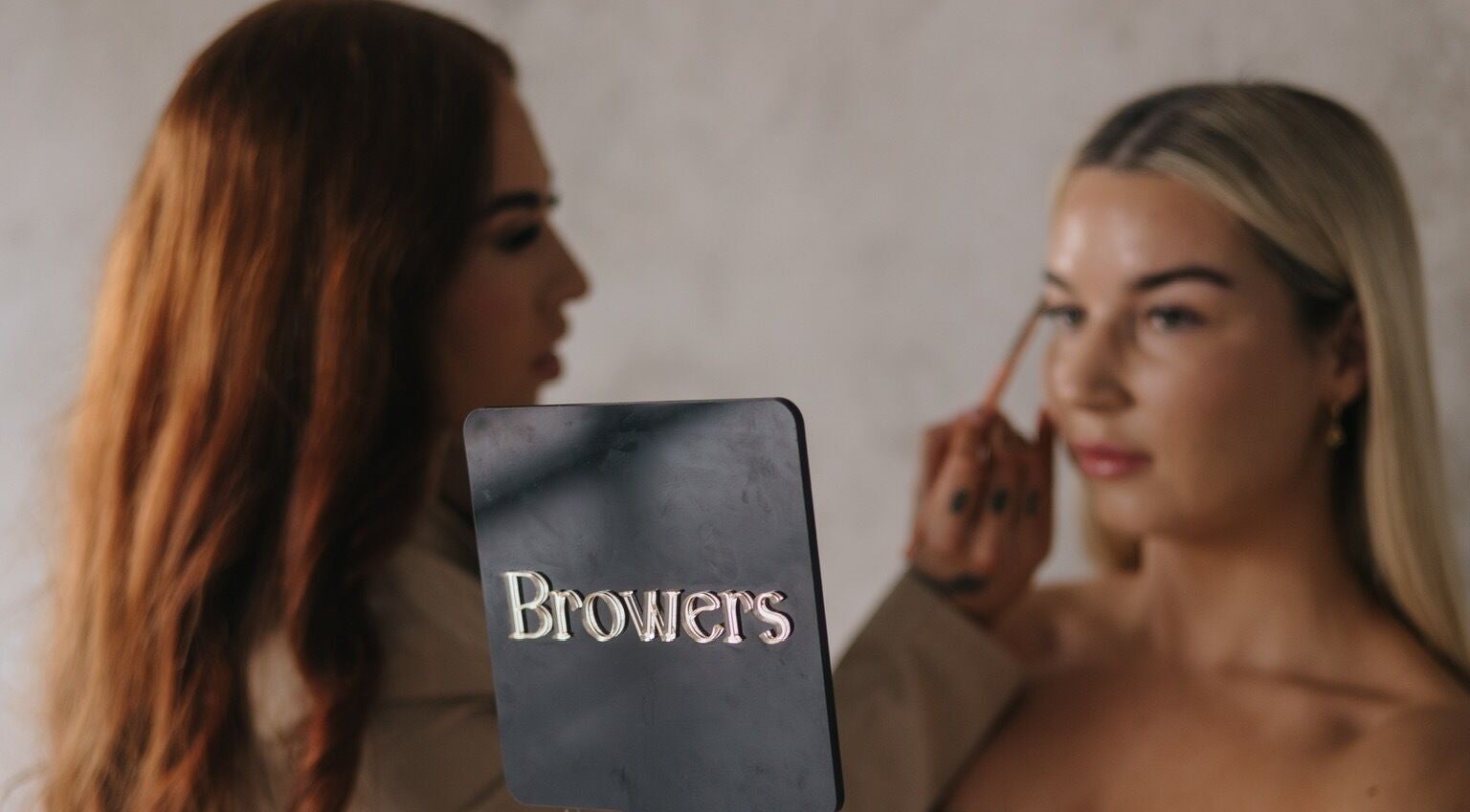 Makeup artist at Browers in Dubbo, New South Wales, AU applying makeup on a client with precision.