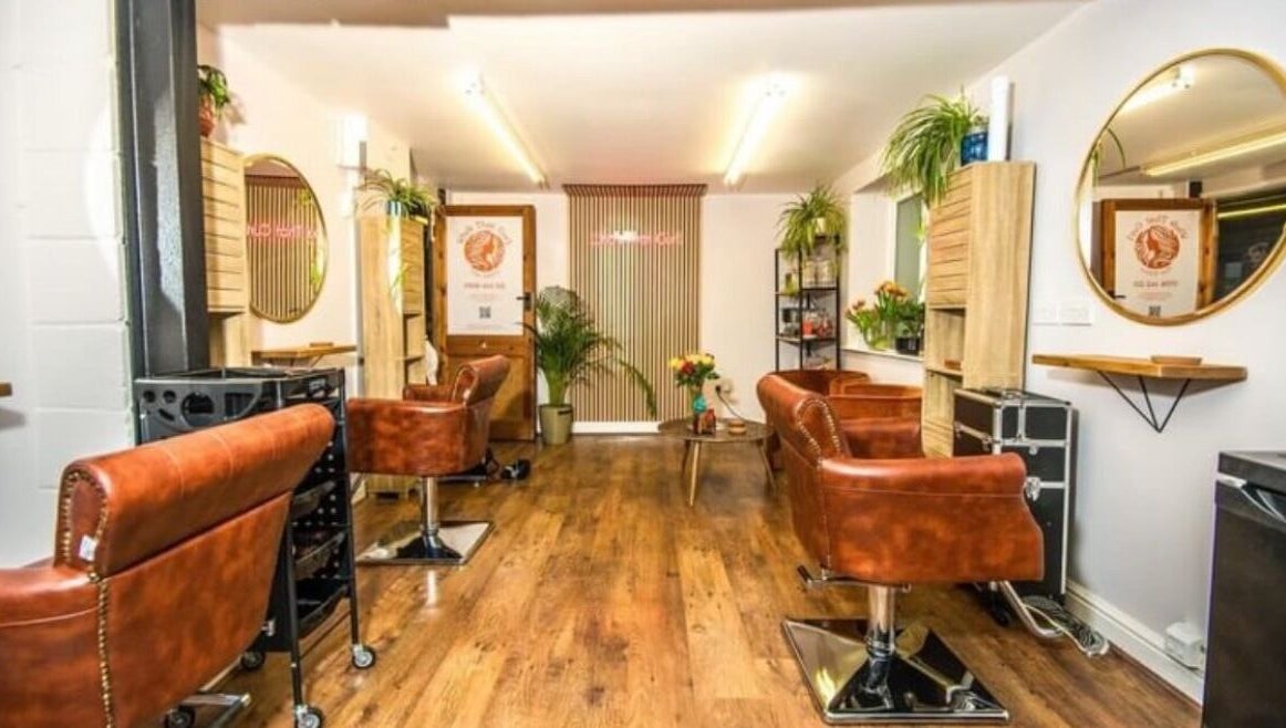 Stylish interior of KW Hairdressing, Braywoodside, England, GB, featuring leather chairs and wall mirrors.