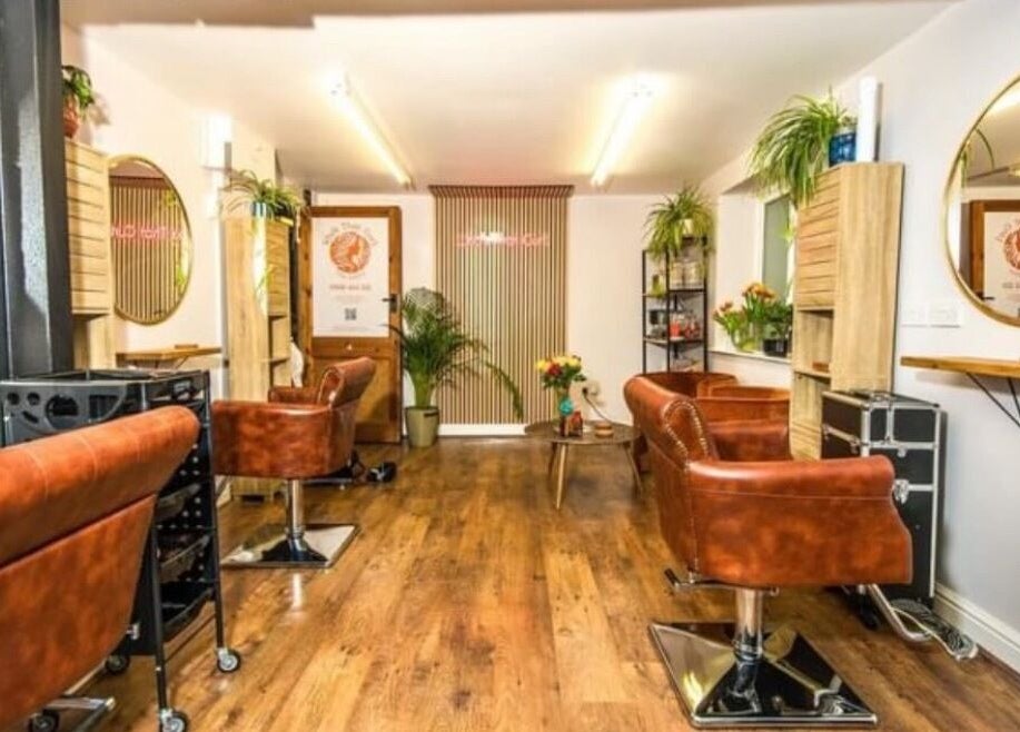 Stylish interior of KW Hairdressing, Braywoodside, England, GB, featuring leather chairs and wall mirrors.
