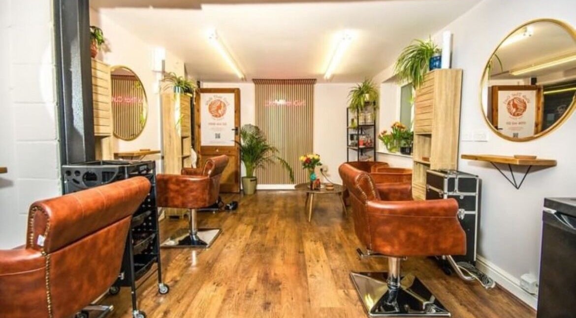 Stylish interior of KW Hairdressing, Braywoodside, England, GB, featuring leather chairs and wall mirrors.