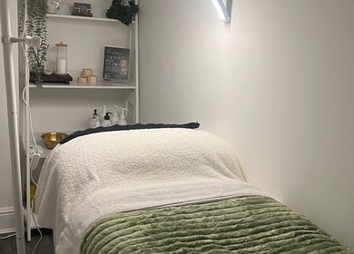 Tranquil treatment room at Emerald Skin Studio, London, England, GB with soft lighting and plush bedding.